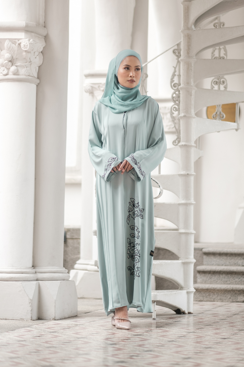 Muslimah Model wearing modest nidha abaya in blue with floral, pleated details on sleeves and hem