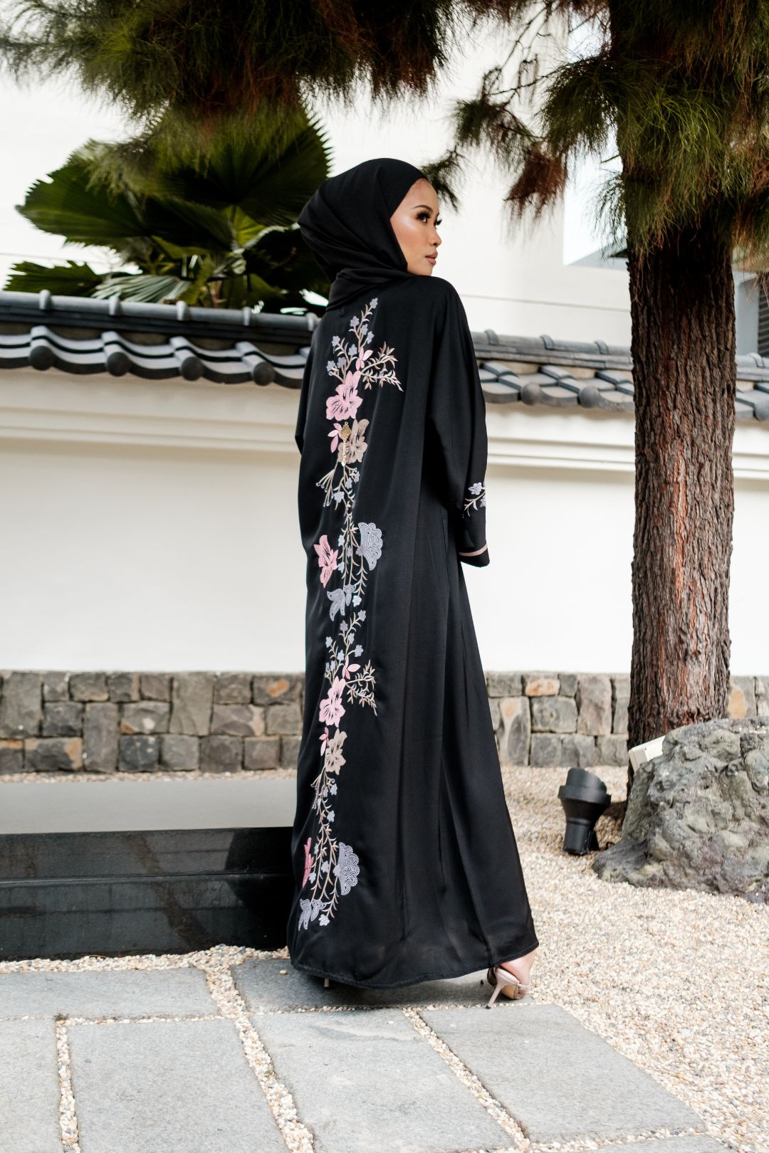 Singapore Muslimah model in hijab wearing black nidha closed abaya with pink and blue floral embroidery. 