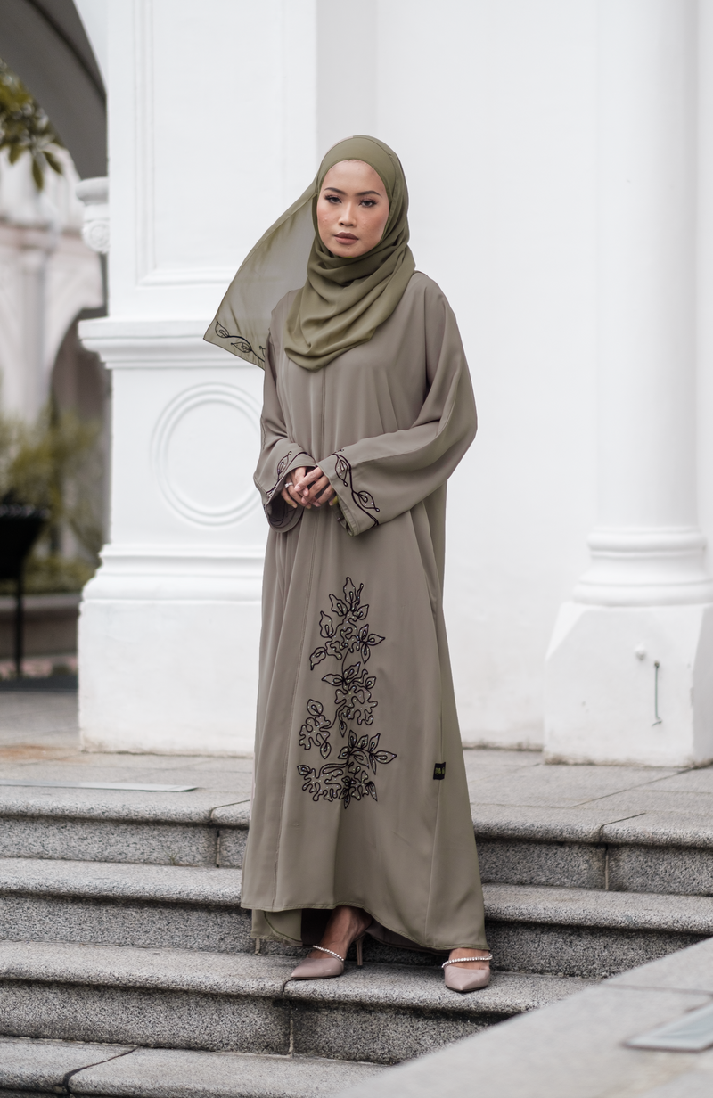 Muslimah Model wearing modest nidha abaya in olive with floral, pleated details on sleeves and hem
