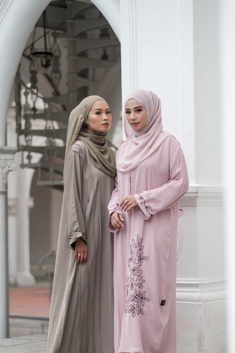 Two Muslimah Model wearing modest nidha abaya in pink and olive with floral, pleated details on sleeves and hem